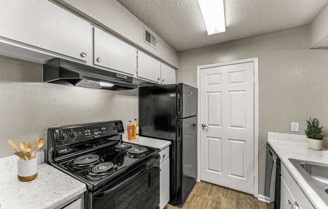 a kitchen with a stove refrigerator and sink