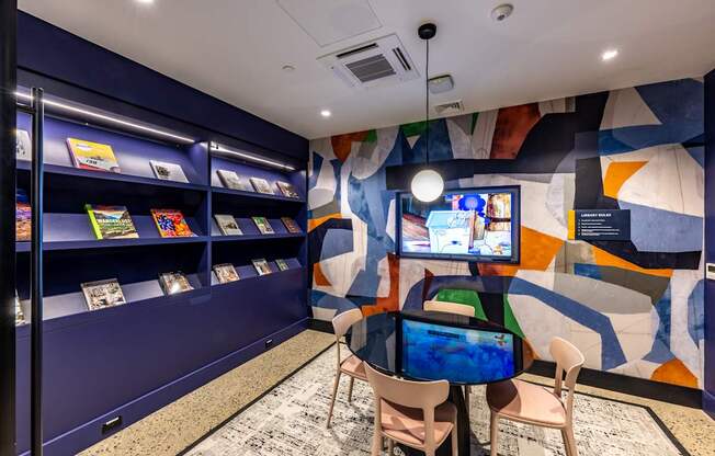 A room with a blue wall and a television on a table.