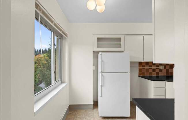 a kitchen with a refrigerator and a window