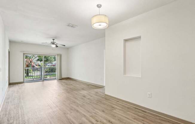 Royal Palm living room with a sliding glass door leading to a private patio at Oakleaf Plantation apartments in Jacksonville, FL.