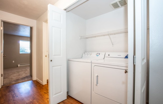 a laundry room with a washer and dryer and a door to a bathroom