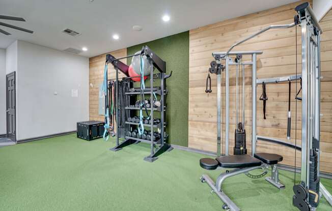 a home gym with a wooden wall and green carpet