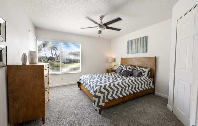 a bedroom with a bed and a ceiling fan