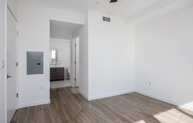 an empty living room with white walls and wood flooring