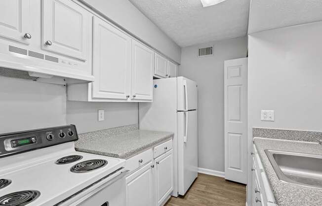 A kitchen with white cabinets and appliances.