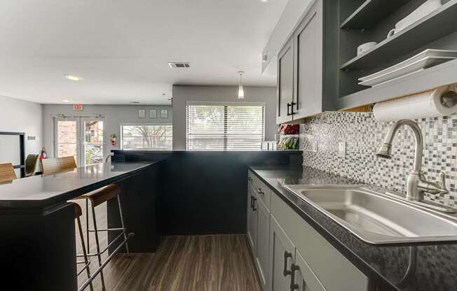 A kitchen with black cabinets and a white countertop.