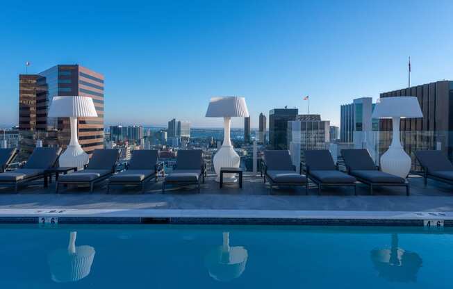 a pool with lounge chairs and lamps on top of a building at Stanza Little Italy, California, 92101