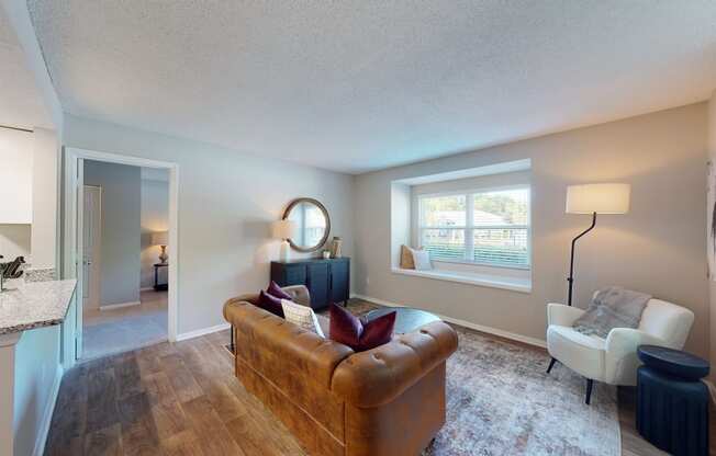 a living room with a couch and chair in front of a window