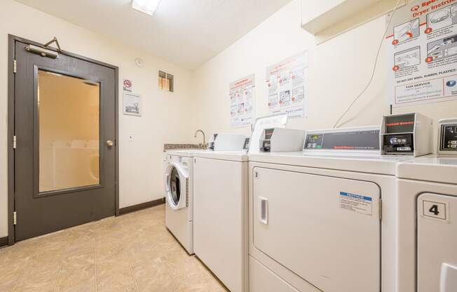 a laundry room with washers and dryers