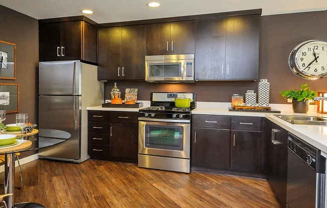 a kitchen with stainless steel appliances and a clock on the wall