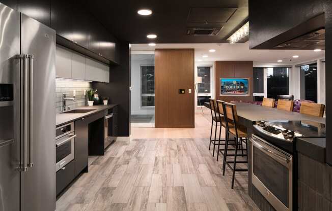 a kitchen with stainless steel appliances and a large island with chairs