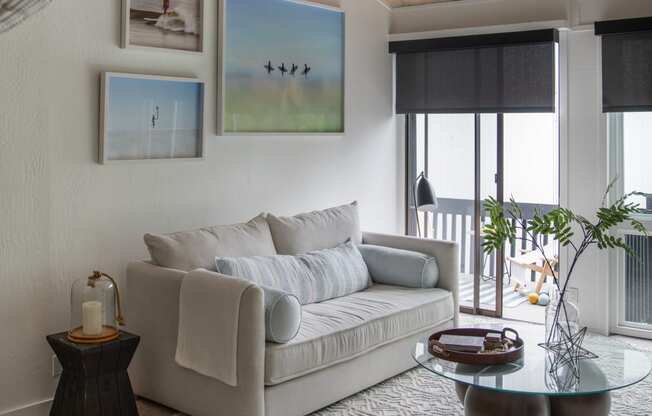 a living room with a couch and a table and a balcony