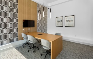 a conference room with a wooden desk and chairs