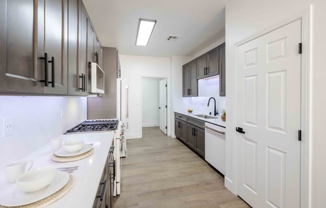 A modern kitchen with white cabinets and a white countertop.