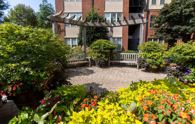 a patio with flowers and a building in the background