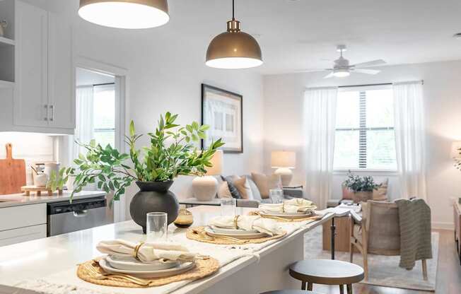 A modern kitchen with a dining table set for two.