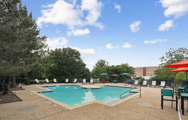 a pool with umbrellas and chairs around it at a hotel