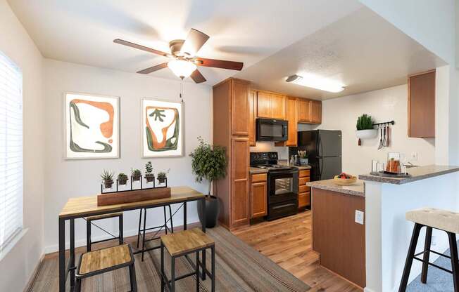 A kitchen with a table and chairs in front of a window.