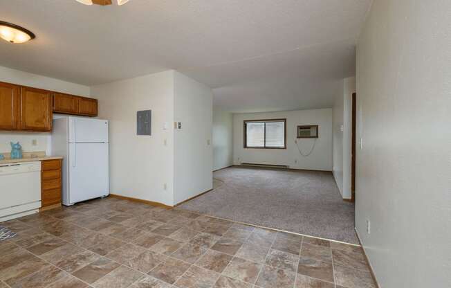 a kitchen with a living room with windows in the background. Fargo, ND Gemstone Apartments