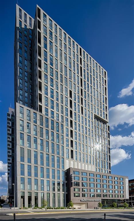 a tall building with a blue sky in the background at The Boro, Tysons, 22102