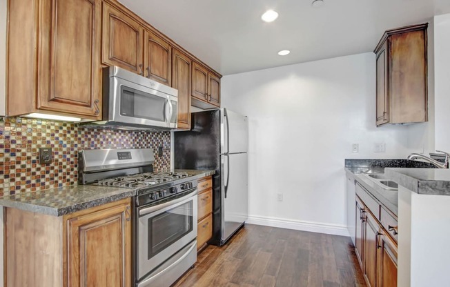 a kitchen with wooden cabinets and stainless steel appliances