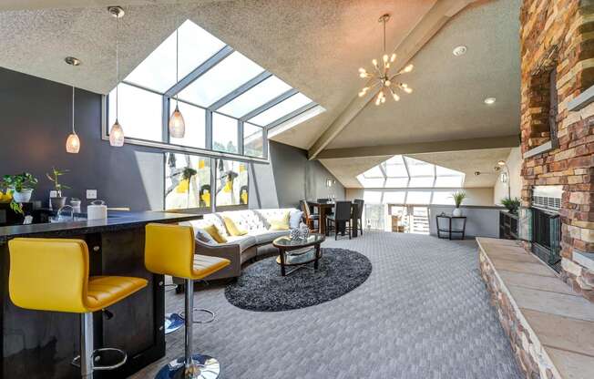 Clubhouse with a bar with yellow chairs and fireplace  at Union Heights Apartments, Colorado Springs, CO