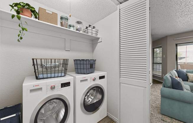 a washer and dryer in a laundry room with a couch