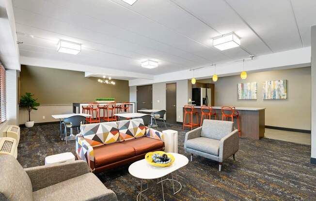 A room with a couch, chairs, and a table.