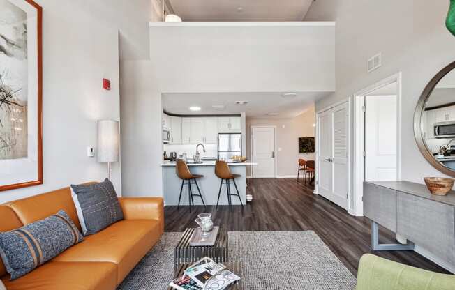 a living area with a couch coffee table and a kitchen in the background at Metro 303, Hempstead, 11550