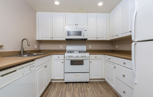 a kitchen with white cabinets and white appliances