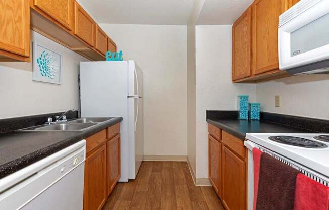 A kitchen with wooden cabinets and a white fridge.