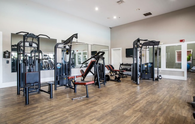a fitness room with cardio machines and other exercise equipment