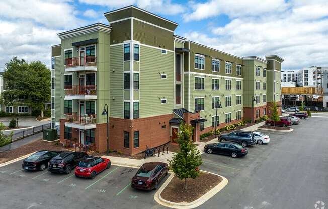 a large apartment building with cars parked in a parking lot