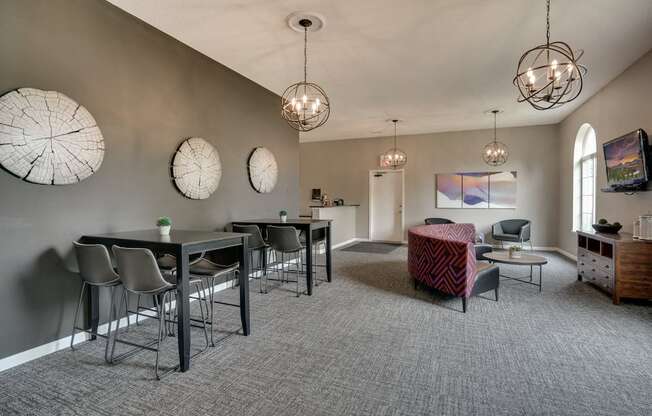community room with tables and chairs, a couch, and a TV on the wall