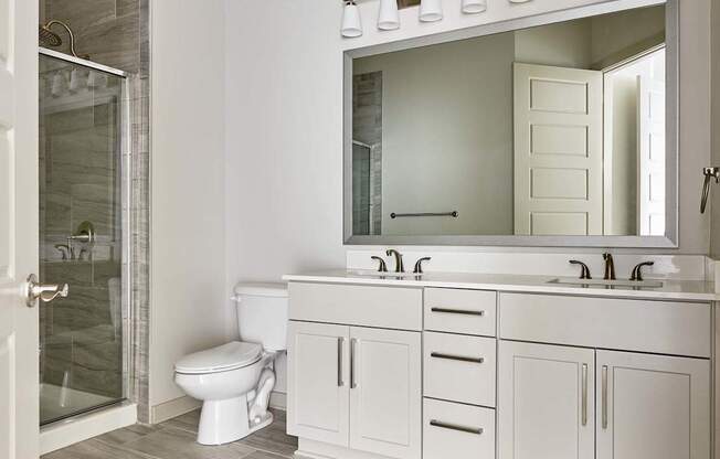 A white bathroom with a toilet, sink, and mirror.