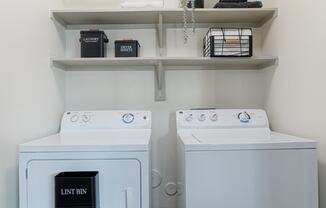 a washer and dryer in a laundry room with shelves