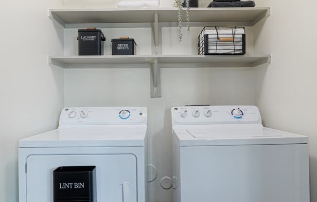 a washer and dryer in a laundry room with shelves