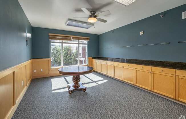 A room with a round table and a ceiling fan.