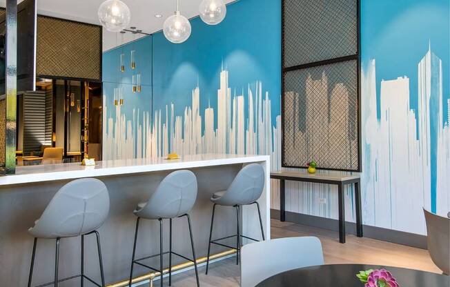 a dining room with a table and chairs and a blue wall with a skyline painted