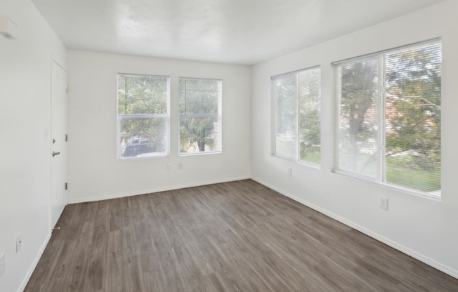 an empty living room with white walls and wood floors