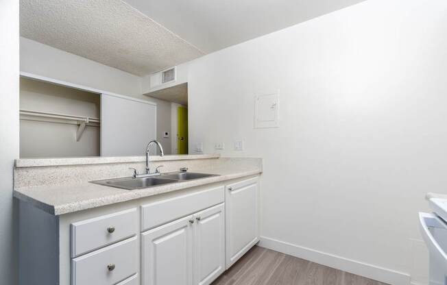 A kitchen with white cabinets and a sink.
