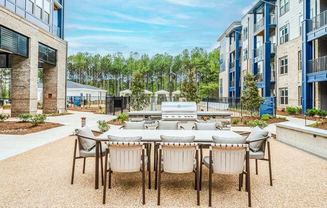 an outdoor patio area with a table and chairs and a grill at Preston Ridge, Cary, 27513