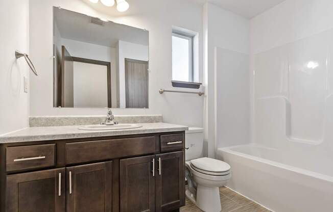A bathroom with a white toilet and a white bathtub.