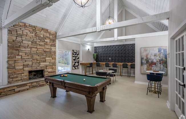 A room with a pool table and a fireplace.