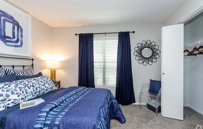 a bedroom with a bed and a window with blue curtains