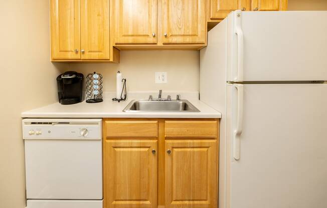 a kitchen with white appliances and wooden cabinets and a refrigerator