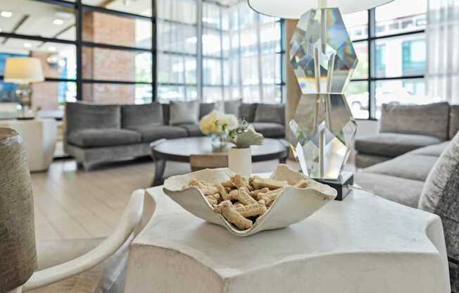 A modern living room with a white coffee table and grey couches.