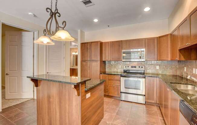 A kitchen with a wooden island and stainless steel appliances.