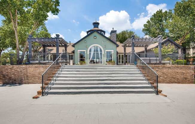 A green building with a black roof and a set of stairs leading up to it.