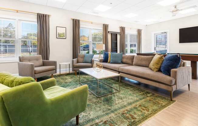 a living room with a couch and chairs and a television